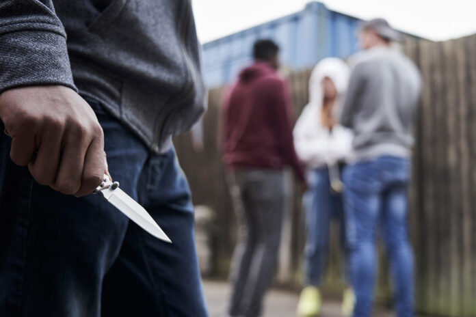 Close,Up,Of,Teenage,Boy,In,Urban,Gang,Holding,Knife